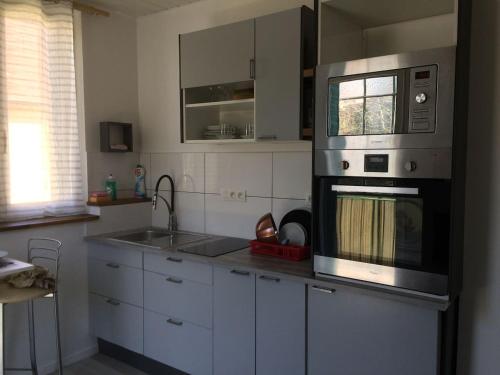 a kitchen with a stove top oven and a sink at Studio Bassens in Bassens
