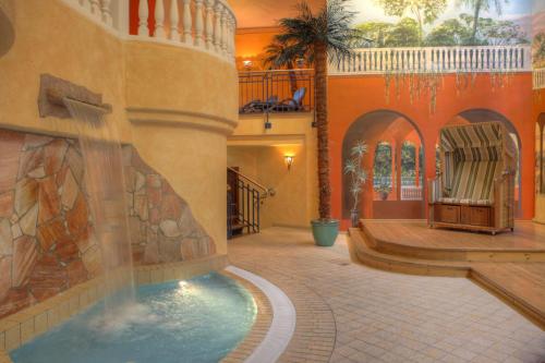 einen Pool in einem Gebäude mit einem Brunnen in der Unterkunft SEETELHOTEL Pommerscher Hof das Wellnesshotel im Herzen der Kaiserbäder mit direktem Zugang zur Wellnessoase Shehrazade in Heringsdorf