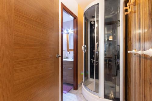 Łazienka z prysznicem i drewnianymi drzwiami w obiekcie Mundaka Home w mieście Mundaka