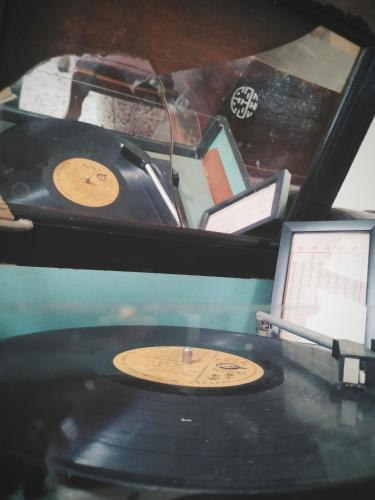 a table with a record player and a clock on it at GOIN Old House & Bar in Tainan