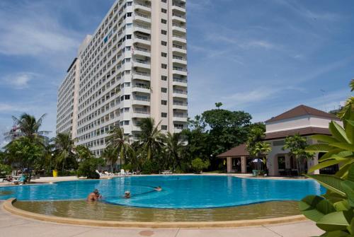 a large swimming pool in front of a tall building at Jomtien View Talay 1 Studio Apartment in Pattaya South