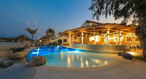 a swimming pool in front of a building at Kundala Beach Resort Hua Hin in Hua Hin