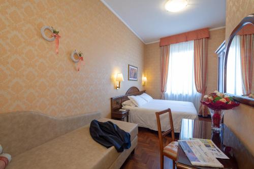 a hotel room with a bedroom with two beds at Hotel Boccaccio in Florence