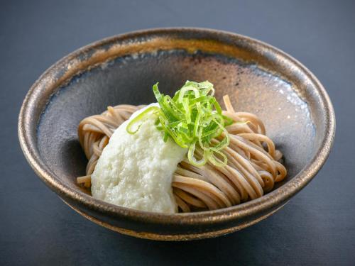 a bowl of pasta with greens on top of it at Awara Onsen Minoya Taiheikaku in Awara