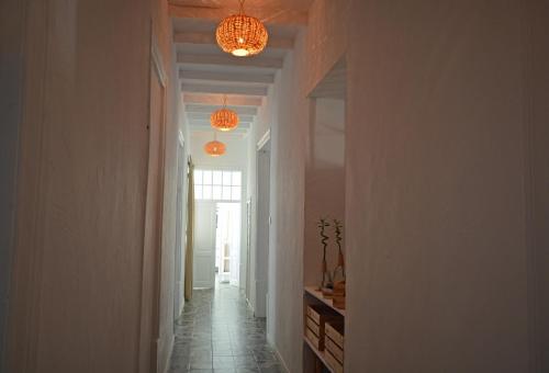 a hallway with two chandeliers and a hallway with a hallway at Old Charming House Faro in Faro