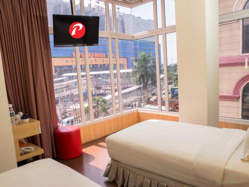 a hotel room with a large window with a television at d'primahotel WTC Mangga Dua in Jakarta