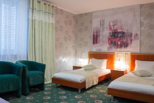 a hotel room with two beds and a chair at Britaniya in Kharkiv