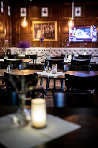 a dining room with tables and chairs with a candle at First Hotel Royal in Säffle