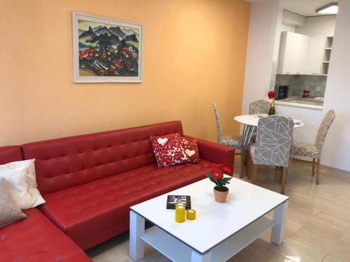 アスコナにあるAscona Residenza Principessaのリビングルーム(赤いソファ、テーブル付)