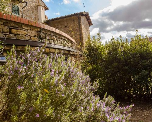 a garden with purple flowers in front of a building at Agriturismo Fattoria Poggio di Fiesole in Fiesole