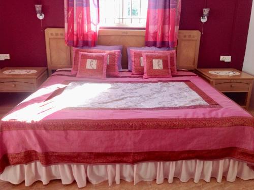 a bedroom with a pink bed with pink curtains at Fayruz Villa is a 3 bedroom, 3 bathroom detached house with AC and swimming pool 5 minutes walk from Flic en Flac public beach in Flic-en-Flac