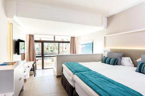 una habitación de hotel con una cama y un escritorio en Grupotel Orquidea, en San Agustín