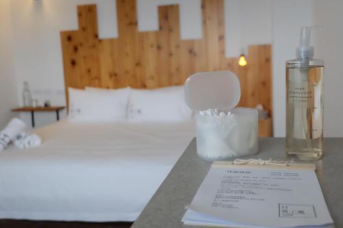 a table with a bottle of moisturizers on a bed at Lof/it in Taitung City