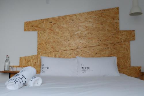 a bedroom with a bed with two pillows on it at Lof/it in Taitung City