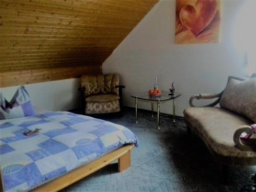 Beuren的住宿－Gästehaus Sonnenhöhe - Ihre Erlebnis-Programm-Schmiede，一间卧室配有一张床、一张沙发和一张桌子