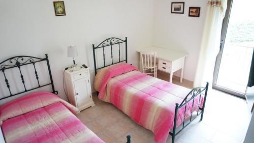 a bedroom with two beds and a table and a window at Agriturismo Costa San Bernardo in Vaglio di Basilicata