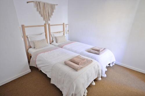 ファロにあるOld Charming House Faroの白い壁の客室内のベッド2台