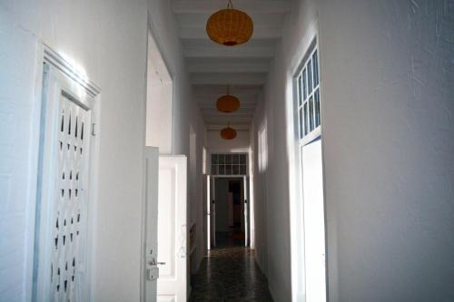 an empty hallway with white walls and two lights at Old Charming House Faro in Faro