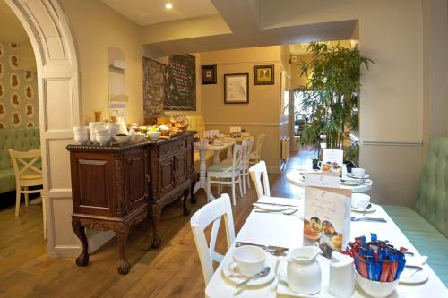 a dining room with a table and chairs and a kitchen at The Old Bank Town House in Kinsale