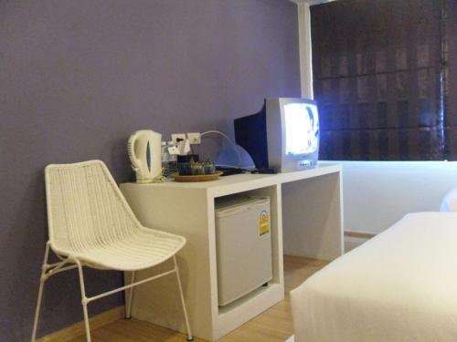 a room with a desk with a tv and a chair at Lantana Pattaya - SHA Extra Plus in Pattaya North