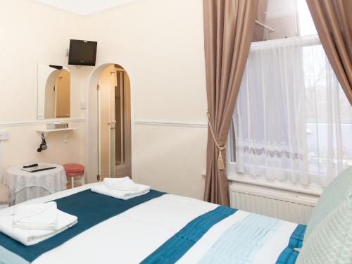 a bedroom with a bed with a mirror and a window at Crimdon Dene in Torquay