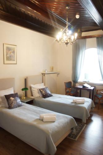 a bedroom with two beds and a chandelier at Pokoje Gościnne Dom Literatury in Warsaw