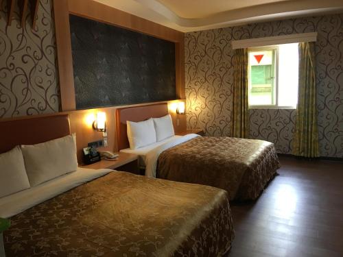 楠梓區的住宿－花鄉旅館連鎖-楠梓店 ，酒店客房设有两张床和窗户。