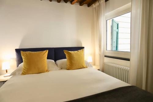 - une chambre avec un lit doté d'oreillers jaunes et d'une fenêtre dans l'établissement San Lorenzo Small Apartment, à Gênes