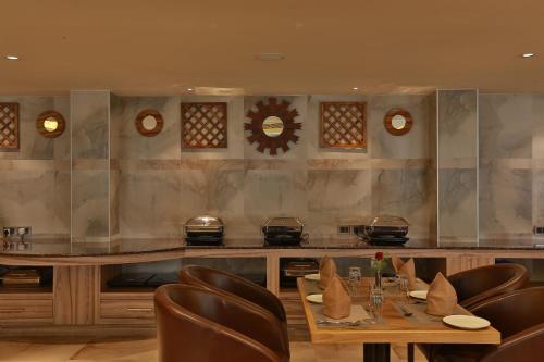 a restaurant with a wooden table and leather chairs at Hotel Luminara in Cochin