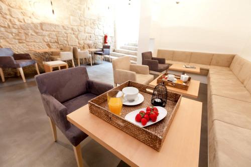 a white table topped with plates of food at InPatio Guest House in Porto