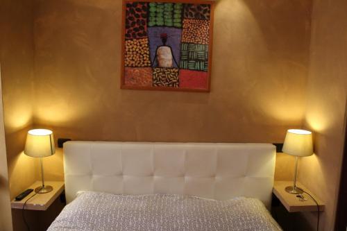 una camera con un letto bianco e due lampade di Centro Storico a Foggia