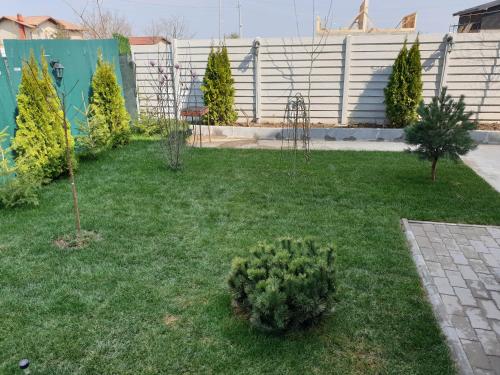 a garden with trees and plants in the grass at VillaGrey Tunari in Tunari