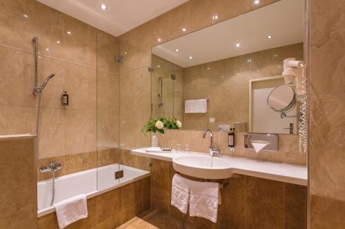 a bathroom with a sink, toilet, and bathtub at Hotel Wandl in Vienna