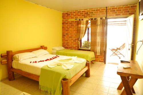 two beds in a room with yellow walls at Fazenda Bom Fim in Nísia Floresta