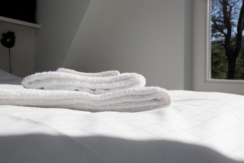 three towels stacked on top of a white bed at Bok's Bungalowpark in Garderen