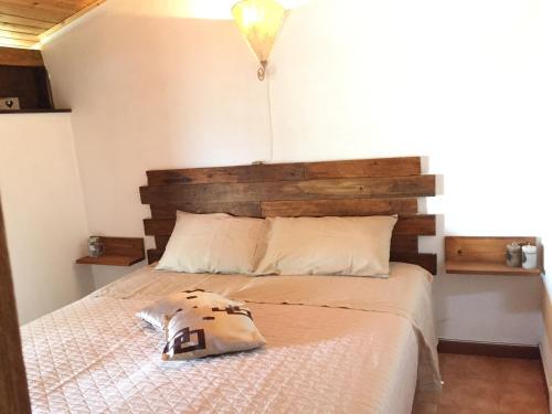 a bedroom with a large bed with a wooden headboard at La Dolce Vita Country House with pool - Solicchiata in Castiglione di Sicilia