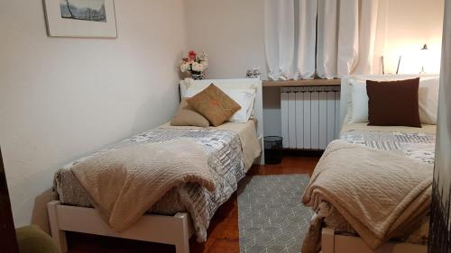 a bedroom with two beds with blankets and pillows at Casa dei Mulini in Mergozzo