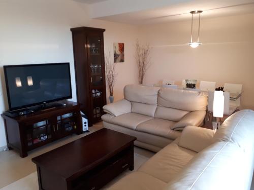 a living room with a couch and a tv at Chalet adosado 3 dormitorios in Sant Jordi