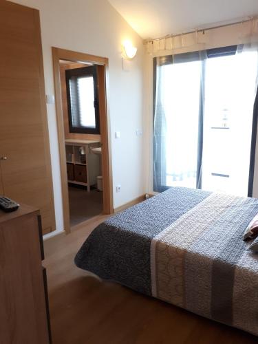 a bedroom with a bed and a large window at Chalet adosado 3 dormitorios in Sant Jordi