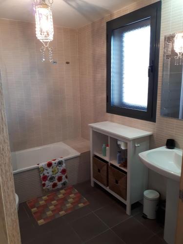 a bathroom with a tub and a sink and a bath tub at Chalet adosado 3 dormitorios in Sant Jordi