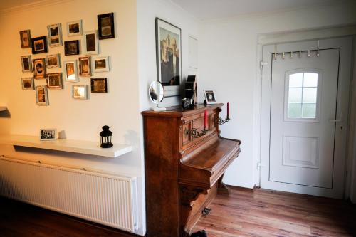 a room with a piano and pictures on the wall at Lindenhof Habernis in Steinberg