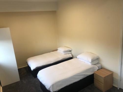 a hotel room with two beds and two lamps at Eazzzy Rooms Corby in Corby