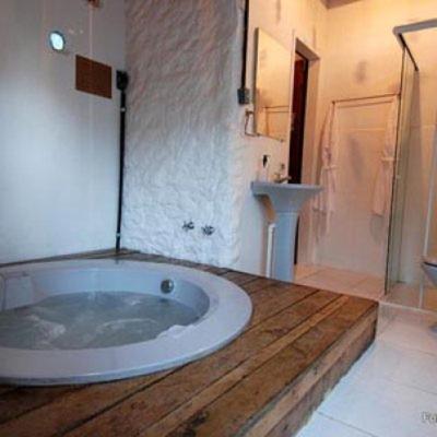 a large bathroom with a tub and a sink at Capricho Asturiano in Santo Antônio do Leite