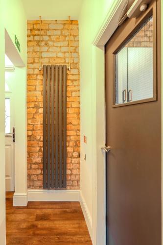 a door in a room with a brick wall at Salisbury Street Guesthouse in Long Eaton