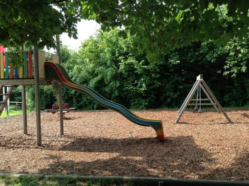 a playground with a slide in a park at Rosenberger Motel Völkermarkt in Völkermarkt