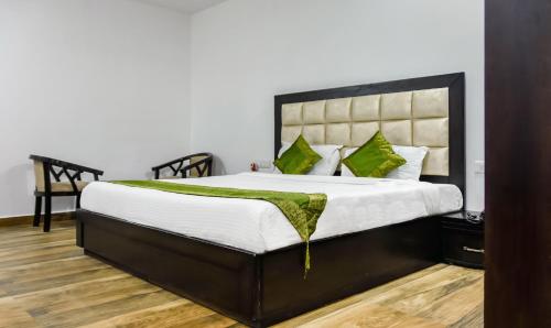 a bedroom with a large bed with green pillows at Treebo Red Petal Jalandhar in Jalandhar