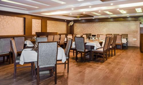 a dining room with tables and chairs and a chalkboard at Treebo Red Petal Jalandhar in Jalandhar