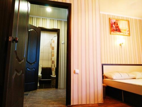 a bedroom with a bed and a bathroom with a shower at центр вулиця Миру in Shostka