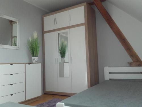 a bedroom with a sliding door with two potted plants at Mazurskie Wzgórze 2 in Rydzewo