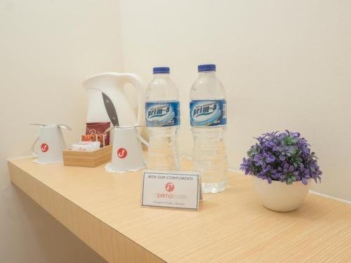 two bottles of water on a shelf with a sign at d'primahotel WTC Mangga Dua in Jakarta